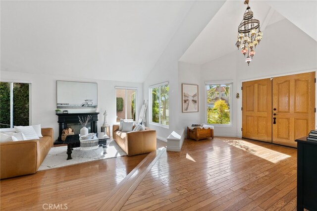 12026 Haven Crest St, Moorpark, CA 93021 - foyer featuring a glass covered fireplace, high vaulted ceiling, light wood-style flooring, and a chandelier