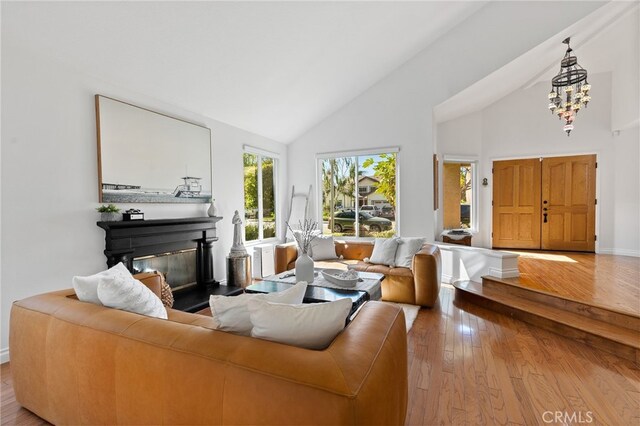 12026 Haven Crest St, Moorpark, CA 93021 - living room featuring high vaulted ceiling, wood-type flooring, a chandelier, and a glass covered fireplace