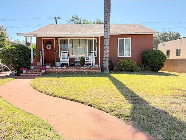 321 N Orange Ave, Rialto, CA 92376 - view of front of property with covered porch, a front lawn, and stucco siding
