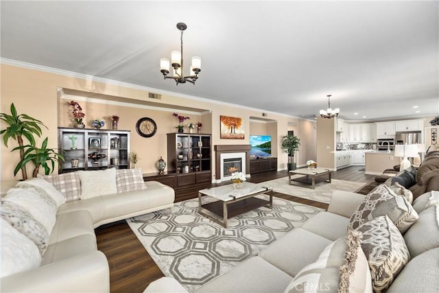 14181 Vai Brothers Dr, Rancho Cucamonga, CA 91739 - living room featuring a chandelier, ornamental molding, wood finished floors, a glass covered fireplace, and recessed lighting