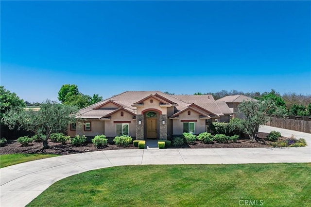 13611 Francisco Dr, Hanford, CA 93230 - view of front of home featuring stucco siding, a tiled roof, and curved driveway