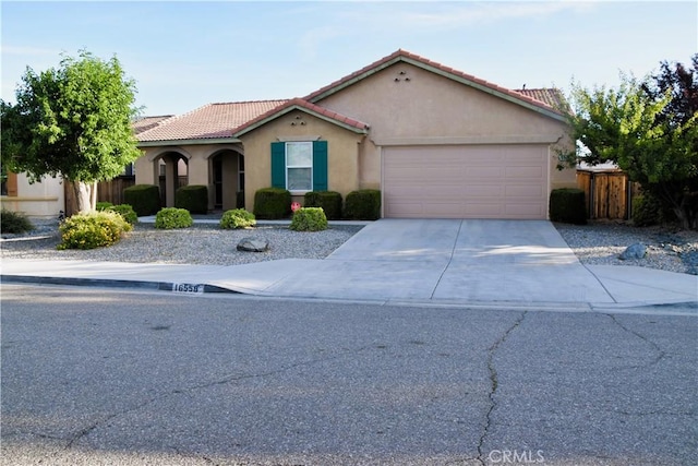 16558 Jasmine St, Victorville, CA 92395 - mediterranean / spanish home featuring stucco siding, a garage, driveway, and a tile roof