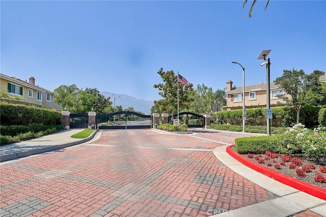 11853 Saybrook Dr, Rancho Cucamonga, CA 91730 - view of decorative road featuring a gate, curbs, sidewalks, street lights, and a gated entry