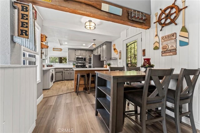32538 Scandia Dr, Running Springs, CA 92382 - dining space with light wood-type flooring, a tray ceiling, washer / clothes dryer, and recessed lighting