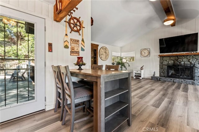 32538 Scandia Dr, Running Springs, CA 92382 - dining room featuring vaulted ceiling, wood finished floors, a fireplace, wooden walls, and ceiling fan