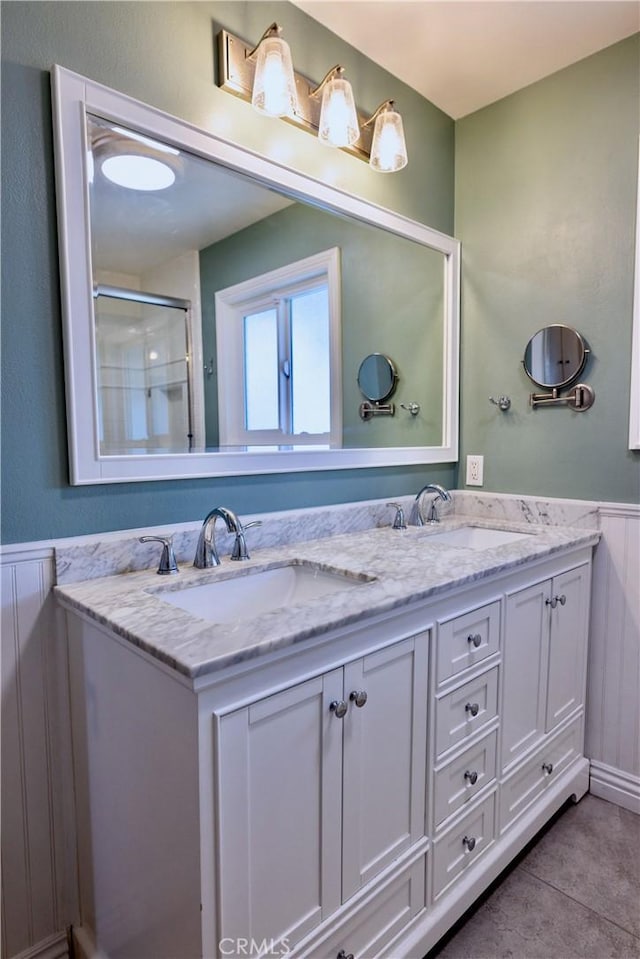 2414 Niagara Way, Costa Mesa, CA 92626 - full bath featuring double vanity, wainscoting, tile patterned flooring, a shower with shower door, and a decorative wall