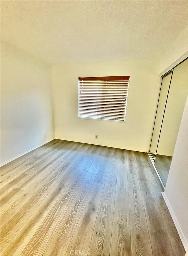 13842 Olive St, Baldwin Park, CA 91706 - unfurnished bedroom with hardwood / wood-style floors, a closet, and a textured ceiling