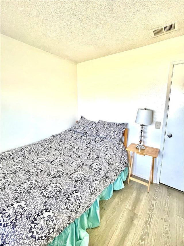 13842 Olive St, Baldwin Park, CA 91706 - bedroom with wood finished floors and a textured ceiling