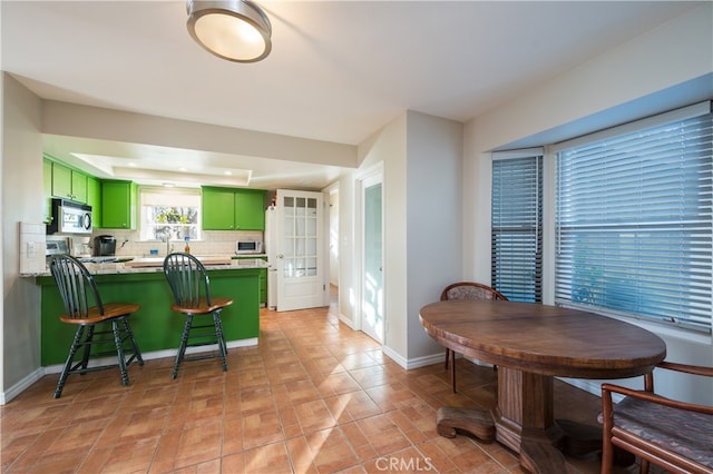 5175 White Tail Pl, Paso Robles, CA 93446 - kitchen featuring green cabinetry, stainless steel microwave, a peninsula, and decorative backsplash