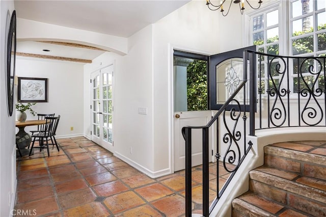 104 Via Lorca, Newport Beach, CA 92663 - foyer entrance featuring arched walkways, a chandelier, beamed ceiling, and stairs