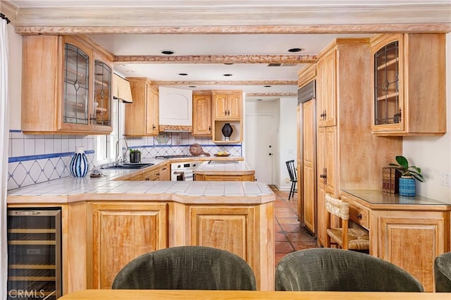 104 Via Lorca, Newport Beach, CA 92663 - kitchen featuring wine cooler, tile counters, a peninsula, white oven, and backsplash