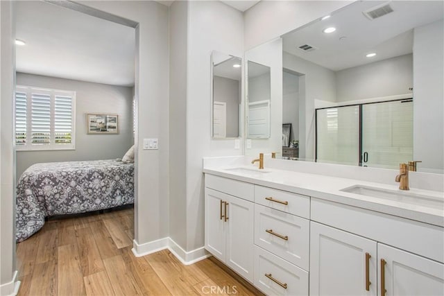 1563 Sunswept Way, Beaumont, CA 92223 - ensuite bathroom with wood finished floors, double vanity, a shower stall, and recessed lighting