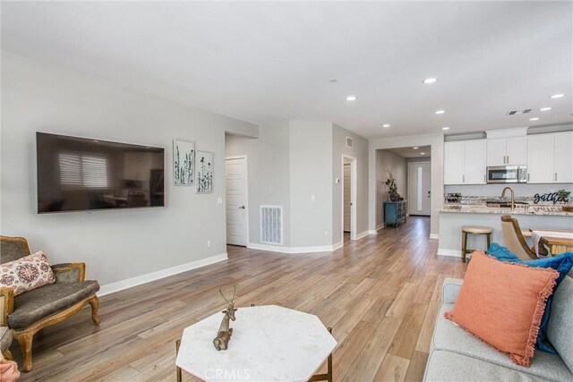 1563 Sunswept Way, Beaumont, CA 92223 - living room with recessed lighting and light wood-style flooring