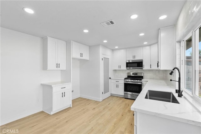 13635 Frady Ave, Chino, CA 91710 - kitchen with stainless steel appliances, light stone countertops, light wood-type flooring, recessed lighting, and decorative backsplash