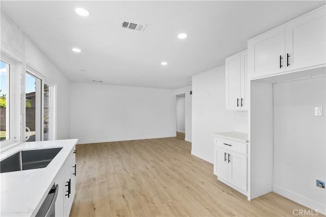 13635 Frady Ave, Chino, CA 91710 - kitchen with recessed lighting, light wood-type flooring, white cabinetry, open floor plan, and light stone counters
