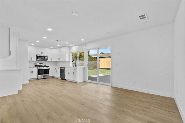 13635 Frady Ave, Chino, CA 91710 - kitchen featuring appliances with stainless steel finishes, light countertops, light wood-style floors, recessed lighting, and white cabinets