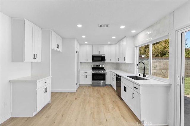 13635 Frady Ave, Chino, CA 91710 - kitchen with stainless steel appliances, light wood finished floors, recessed lighting, white cabinetry, and tasteful backsplash