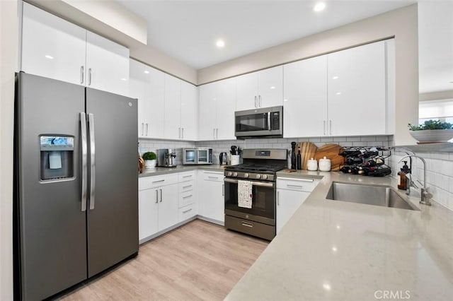 355 N Cleveland St Unit 211, Oceanside, CA 92054 - kitchen featuring stainless steel appliances, light stone countertops, white cabinetry, decorative backsplash, and recessed lighting