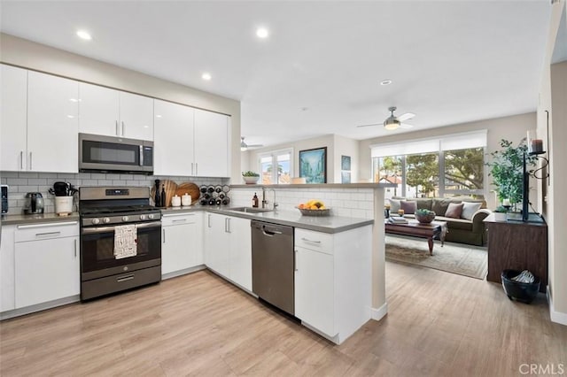 355 N Cleveland St Unit 211, Oceanside, CA 92054 - kitchen featuring appliances with stainless steel finishes, a peninsula, ceiling fan, tasteful backsplash, and open floor plan