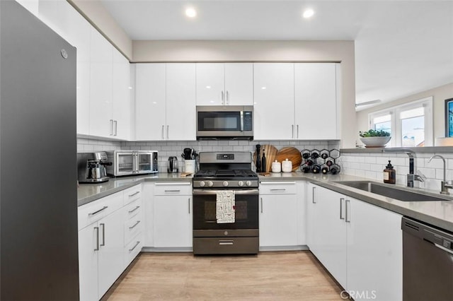 355 N Cleveland St Unit 211, Oceanside, CA 92054 - kitchen with appliances with stainless steel finishes, backsplash, white cabinets, recessed lighting, and light wood-style flooring