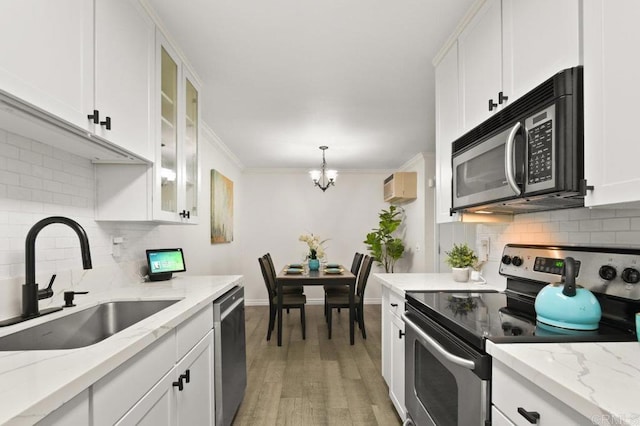 9959 Azuaga St Unit 105, San Diego, CA 92129 - kitchen featuring stainless steel appliances, tasteful backsplash, white cabinets, a chandelier, and crown molding