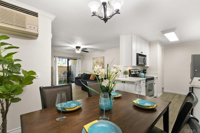 9959 Azuaga St Unit 105, San Diego, CA 92129 - dining area with light wood-type flooring, a wall mounted AC, a chandelier, and a ceiling fan