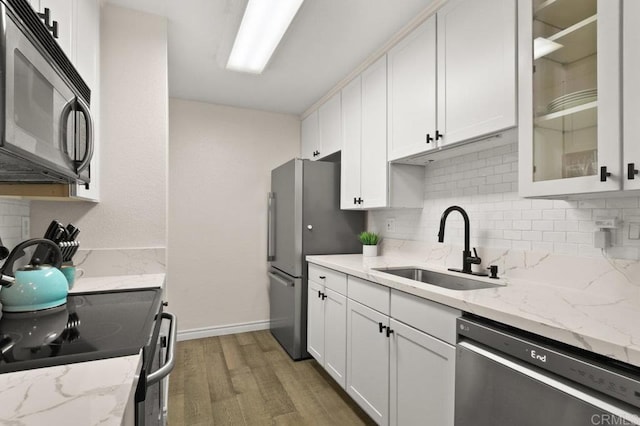 9959 Azuaga St Unit 105, San Diego, CA 92129 - kitchen featuring appliances with stainless steel finishes, light wood finished floors, white cabinets, decorative backsplash, and glass insert cabinets