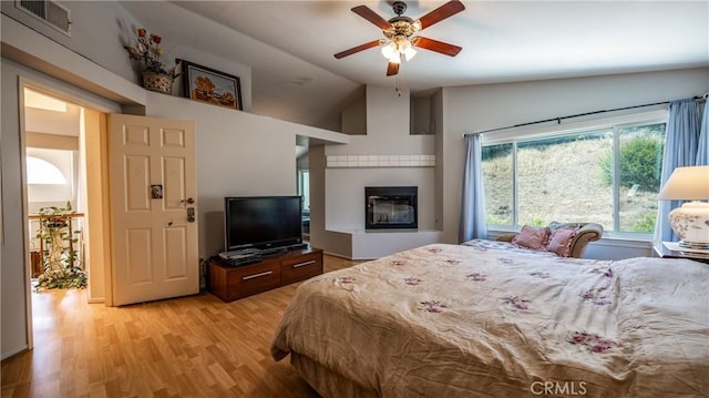 25961 Brookmere Ave, Loma Linda, CA 92354 - bedroom featuring lofted ceiling, light wood finished floors, a glass covered fireplace, and ceiling fan