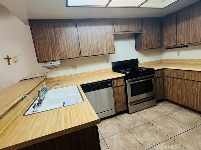 13500 Ramona Pkwy, Baldwin Park, CA 91706 - kitchen with appliances with stainless steel finishes, wood counters, and light tile patterned floors