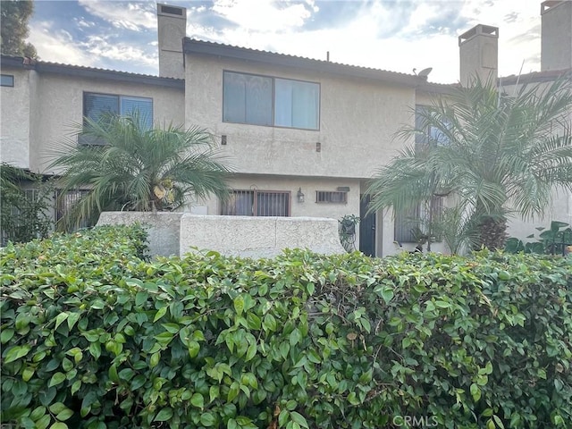 13500 Ramona Pkwy, Baldwin Park, CA 91706 - back of property featuring stucco siding and a chimney