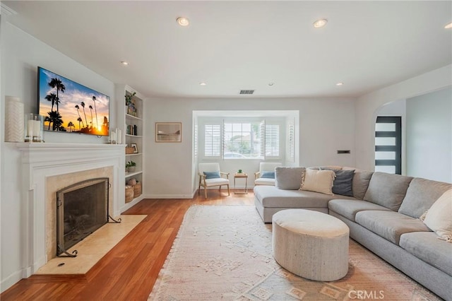 7838 Stewart Ave, Los Angeles, CA 90045 - living room with wood finished floors, built in features, a premium fireplace, and recessed lighting