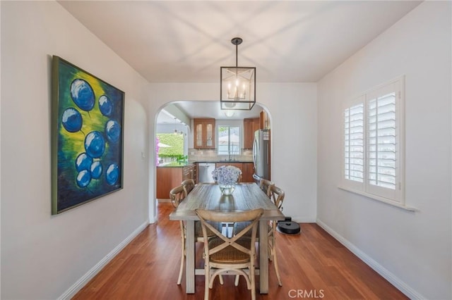 7838 Stewart Ave, Los Angeles, CA 90045 - dining space with arched walkways, wood finished floors, and a chandelier