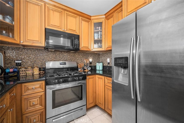 1879 Atlantic Ave Unit 15, Long Beach, CA 90806 - kitchen with stainless steel appliances, light tile patterned flooring, tasteful backsplash, glass insert cabinets, and brown cabinets
