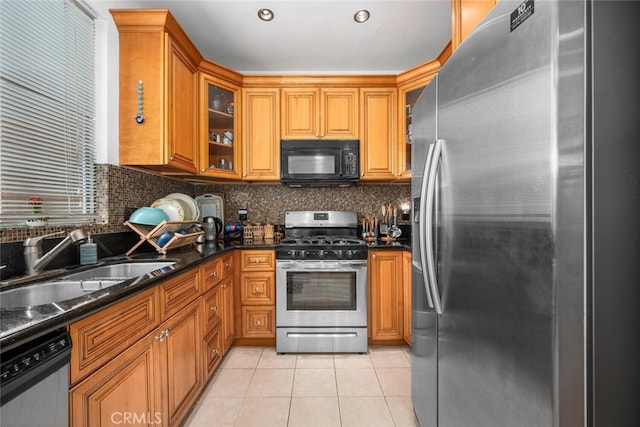 1879 Atlantic Ave Unit 15, Long Beach, CA 90806 - kitchen featuring appliances with stainless steel finishes, brown cabinetry, light tile patterned flooring, and decorative backsplash
