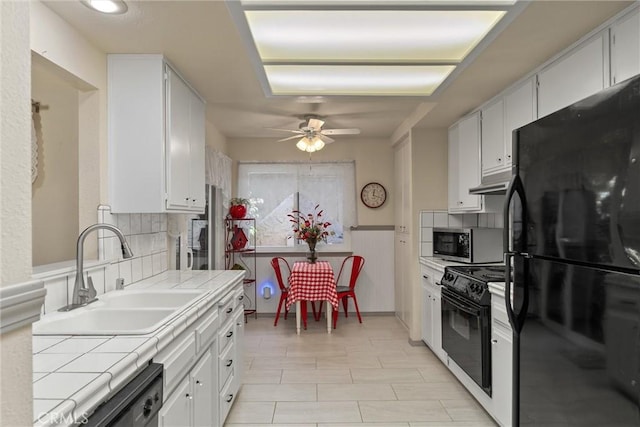 520 Wilshire Ct, Chico, CA 95973 - kitchen featuring black appliances, tile counters, a ceiling fan, white cabinets, and a wainscoted wall