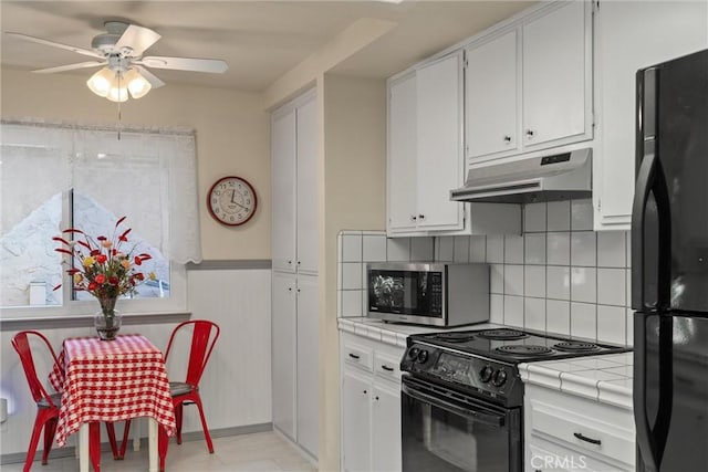 520 Wilshire Ct, Chico, CA 95973 - kitchen featuring tile counters, black appliances, under cabinet range hood, a ceiling fan, and white cabinets