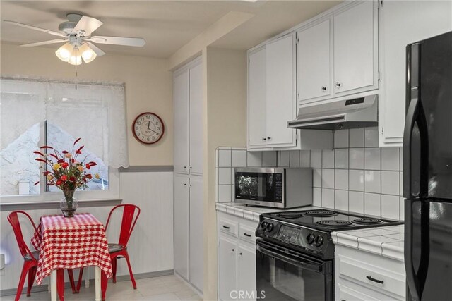 520 Wilshire Ct, Chico, CA 95973 - kitchen featuring tile counters, black appliances, under cabinet range hood, ceiling fan, and white cabinets