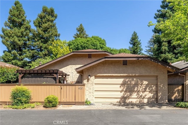 520 Wilshire Ct, Chico, CA 95973 - view of front facade featuring a garage, stucco siding, a pergola, and a gate