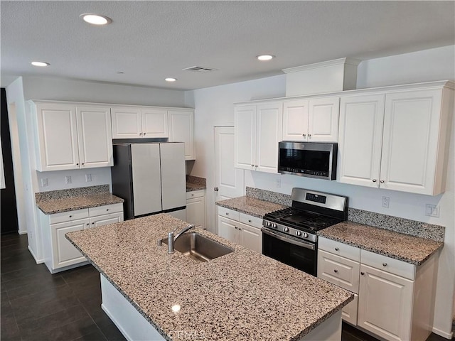 29604 Kyles Cir, Winchester, CA 92596 - kitchen with stainless steel appliances, white cabinetry, recessed lighting, a kitchen island with sink, and light stone counters
