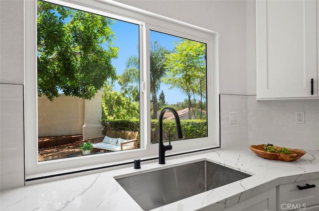 4 Saint Martin, Laguna Niguel, CA 92677 - kitchen featuring tasteful backsplash, light stone countertops, and white cabinetry