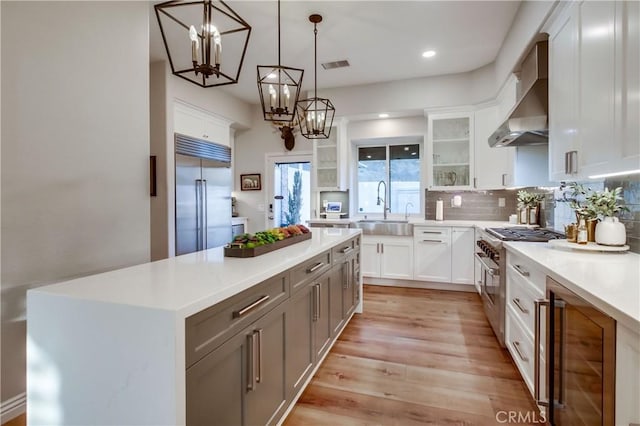 2424 Gird Rd, Fallbrook, CA 92028 - kitchen featuring high end appliances, wine cooler, wall chimney range hood, a chandelier, and light countertops