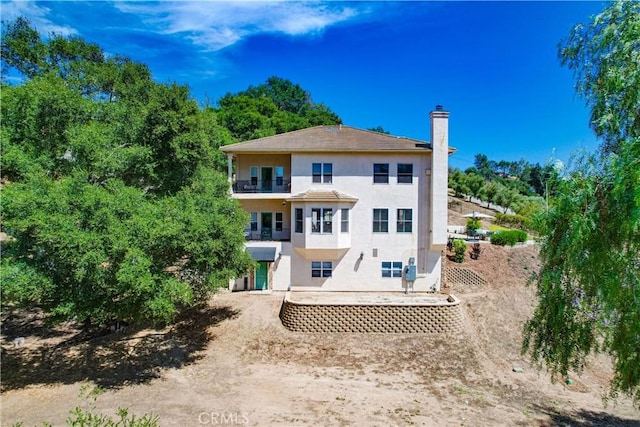 2424 Gird Rd, Fallbrook, CA 92028 - rear view of property featuring stucco siding, a balcony, and a chimney