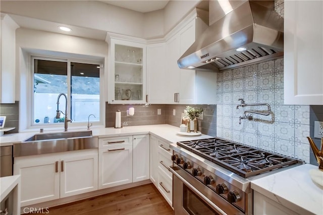 2424 Gird Rd, Fallbrook, CA 92028 - kitchen with wall chimney range hood, high end stainless steel range oven, white cabinets, glass insert cabinets, and tasteful backsplash