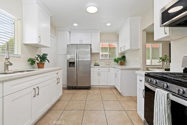 3900 Florence, Bell, CA 90201 - kitchen with stainless steel appliances, white cabinetry, light tile patterned floors, and recessed lighting