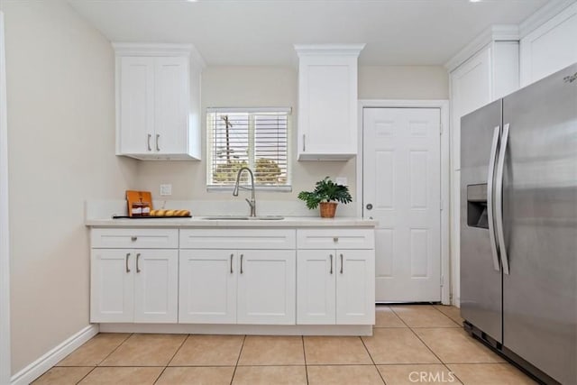 3900 Florence, Bell, CA 90201 - kitchen with stainless steel fridge, white cabinets, light countertops, and light tile patterned flooring