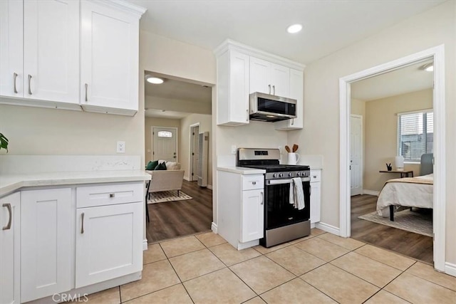 3900 Florence, Bell, CA 90201 - kitchen with appliances with stainless steel finishes, light countertops, white cabinetry, light tile patterned floors, and recessed lighting