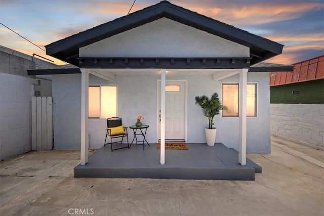3900 Florence, Bell, CA 90201 - back of house at dusk featuring stucco siding and a porch