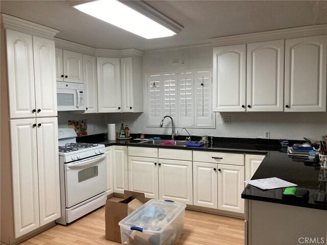 35590 Santa Fe St, Daggett, CA 92327 - kitchen with white appliances, light wood-style flooring, and white cabinetry
