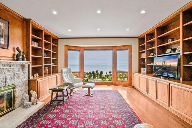 1323 Silvius Ave, San Pedro, CA 90731 - living area with recessed lighting, light wood-style flooring, crown molding, a stone fireplace, and built in shelves
