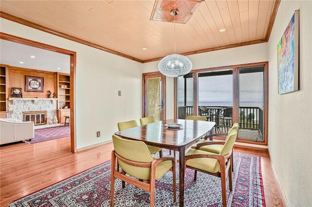 1323 Silvius Ave, San Pedro, CA 90731 - dining area with wood finished floors, wooden ceiling, built in features, crown molding, and a stone fireplace